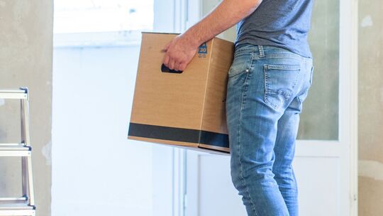 Mann trägt einen Umzugskarton Mann trägt einen Umzugskarton