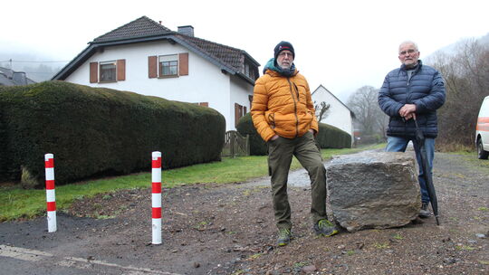 Dieter Rader (links) und Artur Hollender an den beiden Pollern und einem der beiden großen Wackersteine des Anstoßes: Sie forder