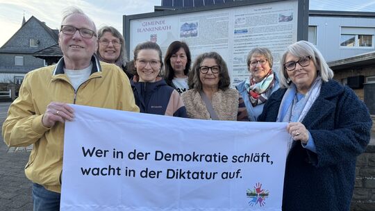 Vertreter der Initiative "Haltung zeigen" halten das Banner mit der Aufschrift "Wer in der Demokratie schläft, wacht in der Dikt