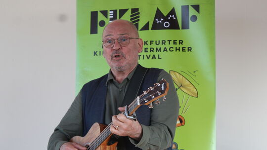 Zum Einstieg ins Pressegespräch sang Georg Feils alias Ferri zur Gitarre "Sternenstaub", den Titelsong des diesjährigen Frankfur