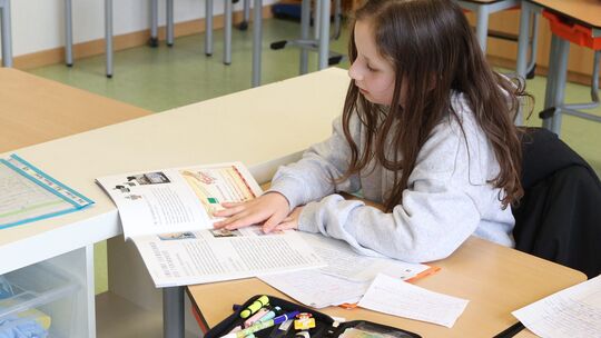 Lucie liest in der "Klicker"-Ausgabe, an der sie selbst mitgewirkt hat.