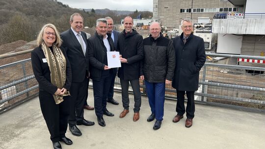 Über den Förderbescheid aus der Hand von Gesundheitsminister Clemens Hoch (3. von rechts) freuen sich (von links) SHG-Baudirekto