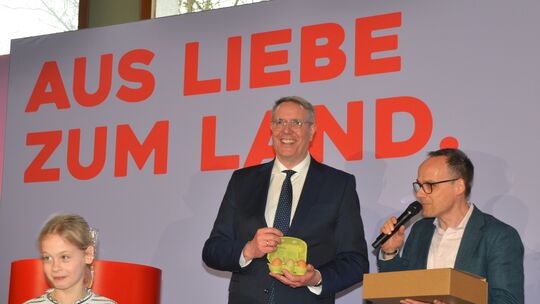 Staatssekretär Dr. Denis Alt überreichte dem Landesvater ein Land-Lunchpaket mit teils eigenen Produkten. Sein Töchterchen Flore