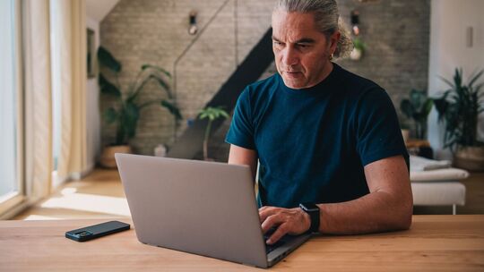 Mann arbeitet an einem Laptop Mann arbeitet an einem Laptop