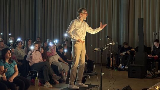 Chorleiter Volker Klein dirigiert seinen Jugendchor und die Musikband während des Konzertes.
