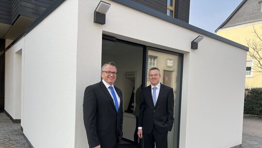 Stolz stehen die beiden Bankdirektoren Jörg Wagner (rechts) und Markus Hofmann vor dem neuen Geldausgabeautomaten an der Raiffei