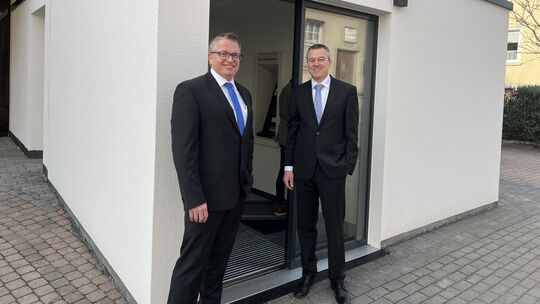 Stolz stehen die beiden Bankdirektoren Jörg Wagner (rechts) und Markus Hofmann vor dem neuen Geldausgabeautomaten an der Raiffei