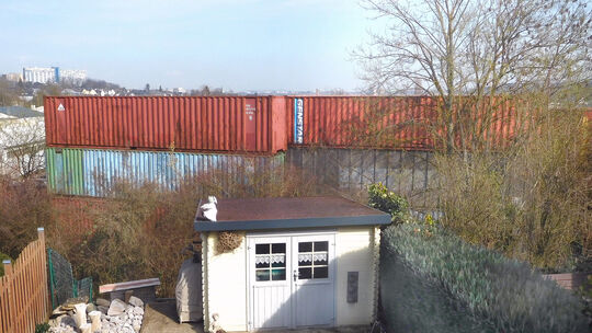 Die Gartenidylle der Eheleute Voigt, die sich gegen diese ungenehmigte Containerwand wehrt. Blick aus dem Ersten Stockwerk ihres