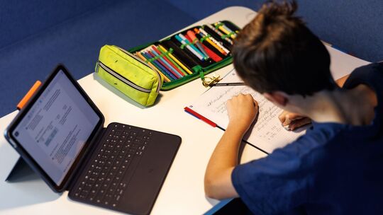 Ein Schüler einer fünften Klasse macht Hausaufgaben