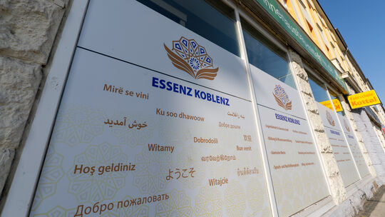 "Herzlich willkommen" steht in vielen unterschiedlichen Sprachen auf den Folien, die der Verein Essenz Koblenz von außen an die