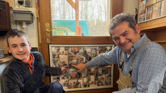 Schreinermeister Frank Seifen zeigt das Bild, auf dem sein neuer Praktikant Tobias Michel zu sehen ist, als er vor acht Jahren b