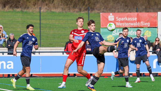 Nick Brabender (rotes Trikot) brachte den Ball im Tor der SG Westerburg (blaue Trikots, von links Niklas Henry, Leonard Ries, To