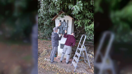 Olaf und Stefanie Pung beim Aufhängen des neuen Reliefs.