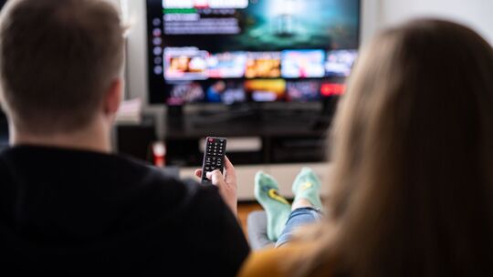 Paar sitzt vor einem Fernseher Paar sitzt vor einem Fernseher