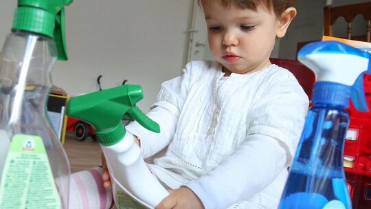Mädchen spielt mit Putzmitteln