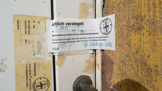 Das Siegel an der Haustür in Koblenz-Neuendorf bedeutet: Hier darf niemand ohne Genehmigung des Bauamtes rein. Doch in der Verga