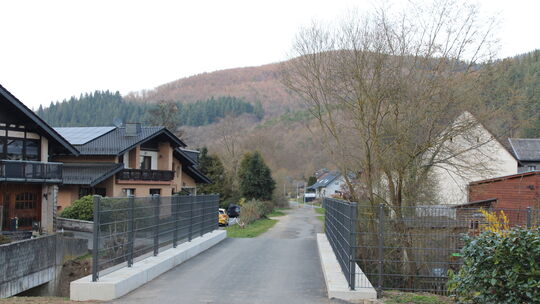 Blick aus der Brückenstraße in der Ortsmitte von Niederadenau auf die nach Flutschäden sanierte ehemaligen Bahnbrücke über den A