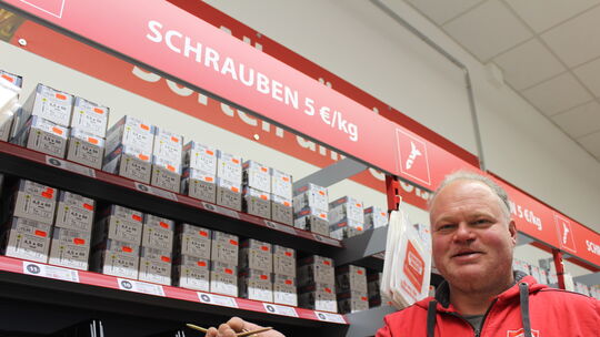Geschäftsführer Sven Fülling vor dem großen Schrauben- und Einzelteile-Sortiment in den Regalen des Baumarktes. Hier, "wo die Sc