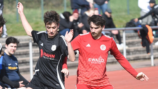 Der Bad Sobernheimer Axel Neumann (rotes Trikot) stellt einem Gegenspieler von der SG Gräfenbachtal ein Bein, die Gäste nehmen a