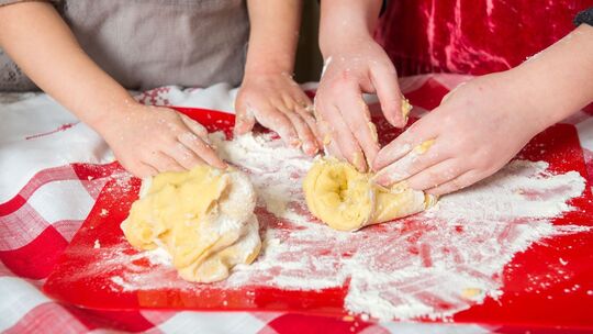 Zwei Mädchen kneten rohen Teig Zwei Mädchen kneten rohen Teig