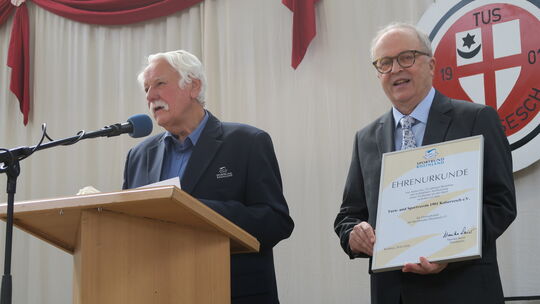 Walter Desch überreicht Gerd Michaely (rechts), dem Vorsitzenden des TuS Kaisersesch, die Ehrenurkunde des Sportbundes Rheinland