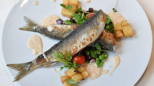 Gebratene Heringe mit Favabohnen und Risoleekartoffeln.