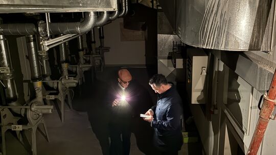 Bauherr Horst Schenk (links) zeigt Oberbürgermeister Emanuel Letz (rechts) die Lüftungsanlage des Bunkers im Brückes.