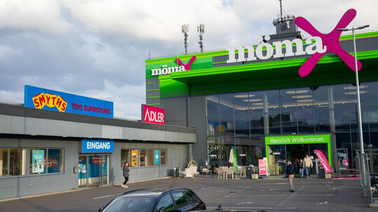 Die Geschäfte Smyths Toys, Adler Mode und Mömax in Koblenz an der B9. Weil direkt neben Mömax eine XXXLutz-Filiale geplant ist,