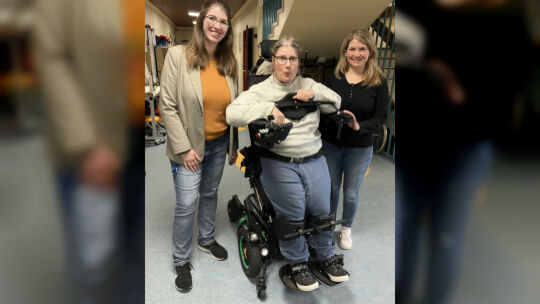 Hannah van Bonn, Leiterin der Fördersdtätte (links) und Ergotherapeutin Sarah Olberts mit Sophie in ihrer Mitte, die durch die H