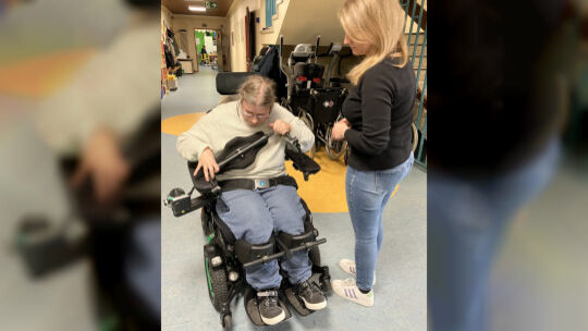 Betreuerin und Ergotherapeutin Sarah Olberts greift beim Umbau des Rollis für die Stehpositionierung nur ein, wenn Sophie Unters