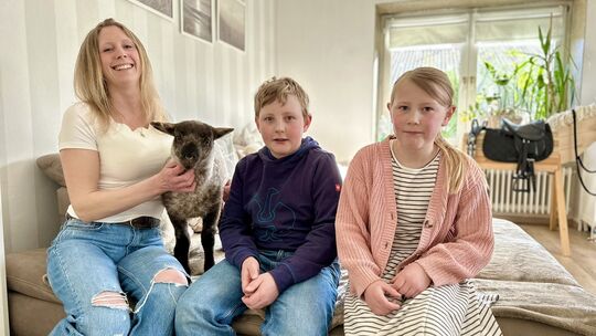 Caroline Raymann und ihre Kinder Elias und Maja machen es sich gerne auf dem Sofa im Wohnzimmer gemütlich. Immer mit dabei: Lamm