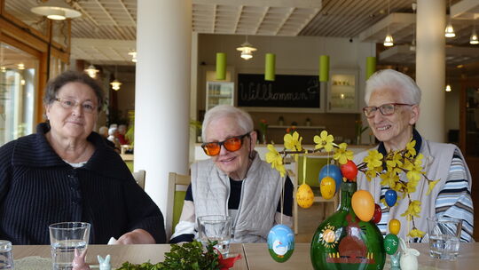 Um einen bunten Osterstrauß versammelt, erzählen (von links) Monika Hirschenbaum, Trudi Günnemann und Eva Küster von Ostern, so,
