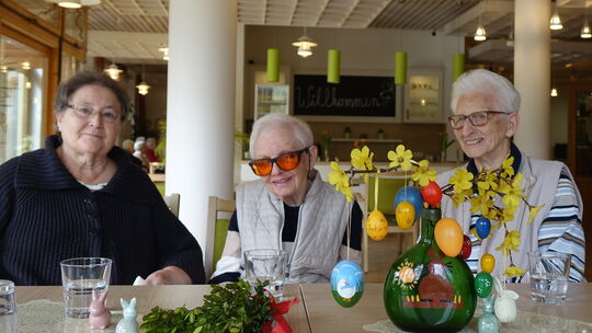 Um einen bunten Osterstrauß versammelt, erzählen (von links) Monika Hirschenbaum, Trudi Günnemann und Eva Küster von Ostern, so,