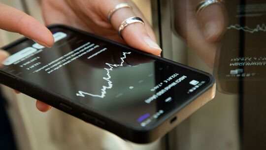 Eine Frau nutzt eine Finanz-App auf einem Smartphone