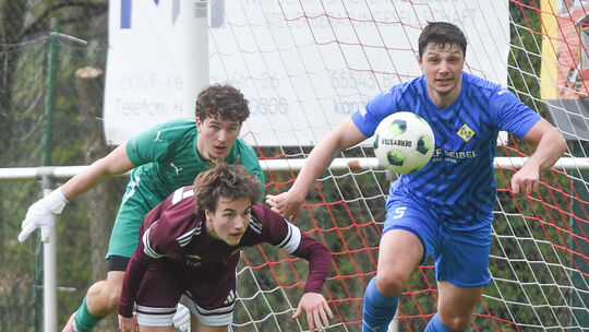 Tiefflug: Der Schmittweilerer Milan Klein (rotes Trikot) versucht, per Flugkopfball den Abwehrspieler und den Torwart des SC Hau