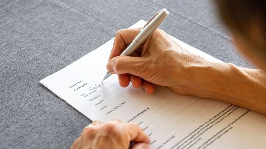 Eine Frau füllt eine Vollmacht aus