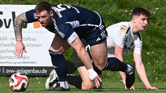 Wallmenroths Kapitän Kevin Fischbach (in Blau) musste sich auf heimischem Platz gegen den SV Adler Niederfischbach (in Weiß) ges