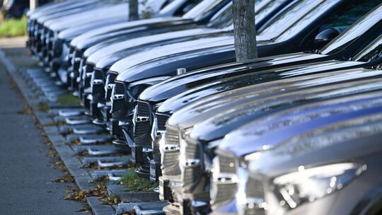 PKWs stehen vor einem Autohaus