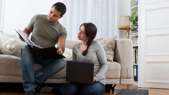 Ein Paar sieht gemeinsam in Unterlagen