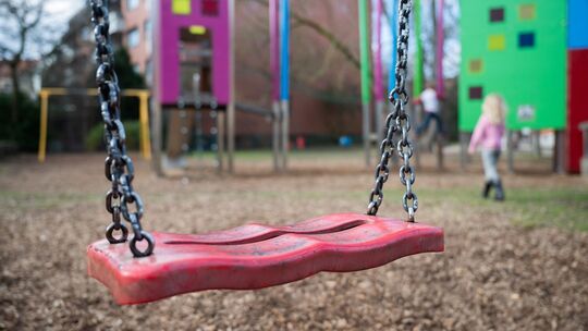 Eine Schaukel hängt auf einem Kinderspielplatz Eine Schaukel hängt auf einem Kinderspielplatz