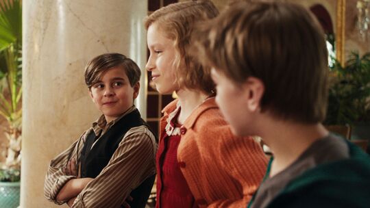 Georg, Hannah und Karli (Maximilian Reinwald, Annika Benzin, Silas John von links) erleben in "Das geheime Stockwerk" 1938 Abend