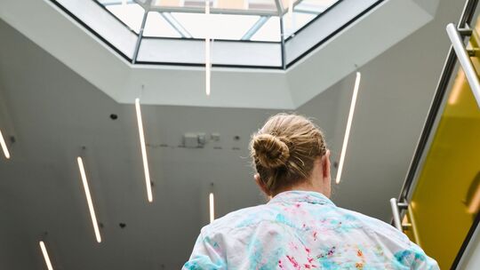 Eine Frau geht in einem Bürohaus eine Treppe hoch
