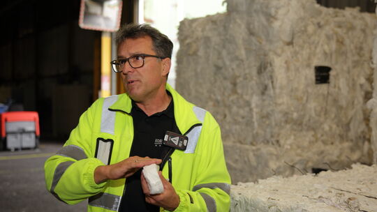 Christian Scherwa, Teamleiter Ingenieure bei Kimberly-Clark in Koblenz, vor gepressten Bündeln an Altpapier.