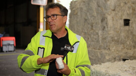 Christian Scherwa, Teamleiter Ingenieure bei Kimberly-Clark in Koblenz, vor gepressten Bündeln an Altpapier.