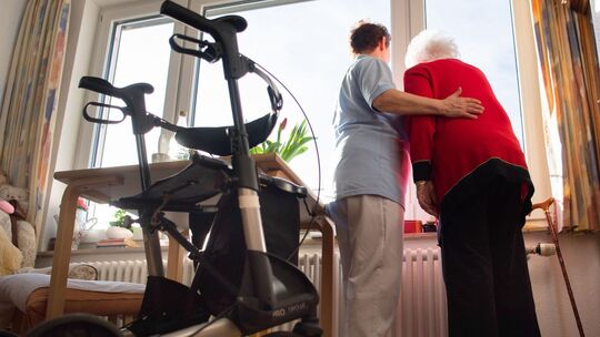 Eine Pflegerin unterstützt eine Heimbewohnerin