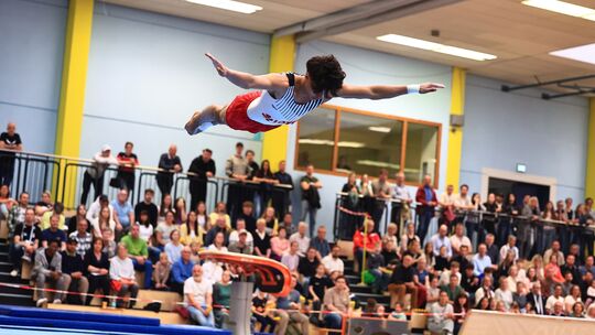 Elias Jaffer fliegt förmlich durch die Luft bei seiner Bodenübung und lässt die 500 Zuschauer in der Sporthalle auf dem Asterste