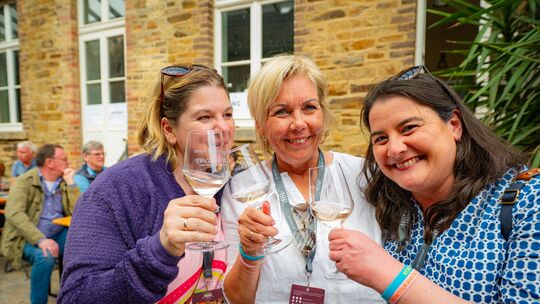 Drei Damen stoßen bei der Winzergenossenschaft Dagernova an.