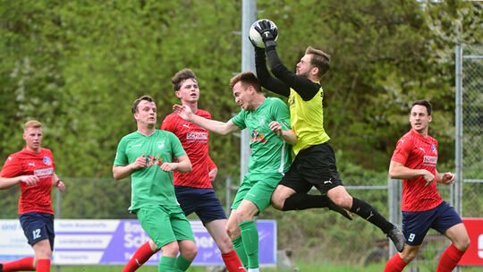 Den Ball fest im Griff hat hier Mörschbachs Torhüter Leon Roth, der Oberzissener John Marc Schneider (vorn in Grün) kommt nicht
