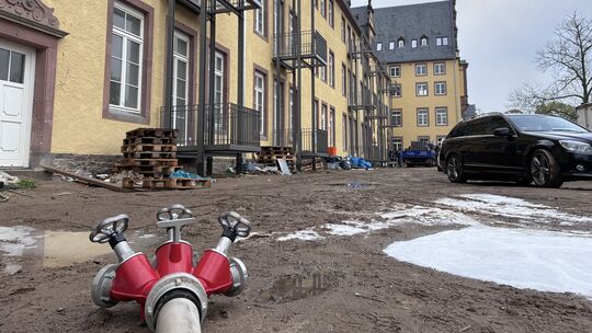 Am Morgen nach dem Brand auf dem Oberwerth in Koblenz liegt noch ein Löchwasserverteilrohr am Boden vor dem denkmalgeschützten P