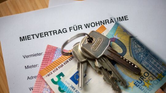 Mietvertrag, Geldscheine und Hausschlüssel auf einem Tisch